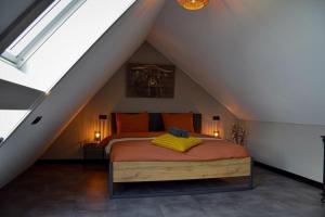 a bedroom with a bed in the attic at Het Bruineveld in Daarle +67 photos