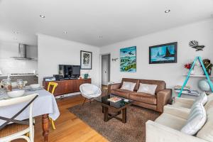 a living room with a couch and a table at Belmont Beach House - Whangarei Heads Escape in Whangarei