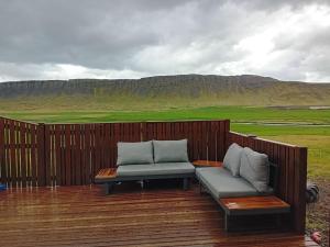 a bench sitting on a wooden deck with a view at Hóll Guesthouse in Akranes