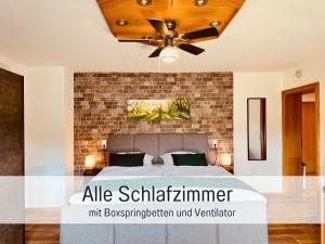 a bedroom with a bed with a brick wall at Nur 15 Minuten bis Fulda - ideal zum Arbeiten - Am Vulkanradweg - 3 Schlafzimmer Große Terrasse - Grill - Ferienhaus Taufstein 1 in Herbstein