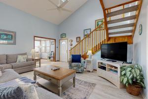 a living room with a couch and a tv at OIB28 Summer Sands in Ocean Isle Beach