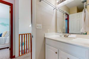 a bathroom with a sink and a mirror at OIB28 Summer Sands in Ocean Isle Beach +18 photos