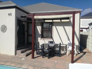 a pavilion with a table and chairs on a patio at Captain's Sea Cabin in Cape Town