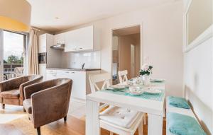 ブレ・デューンにあるCozy Apartment In Bray-Dunes With Wifiの白いテーブルと椅子のあるキッチンとダイニングルーム