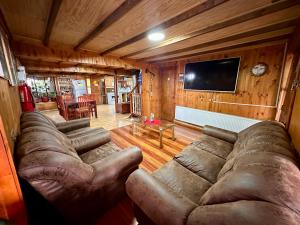 a living room with a couch and a flat screen tv at Hosta Altos de Gamboa in Castro