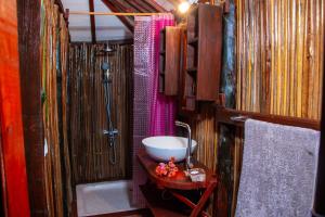 a bathroom with a sink and a shower and a bowl at Ampazôny Oasis Lodge in Mahajanga
