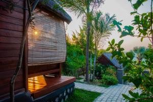a wooden house with a deck and a patio at Ampazôny Oasis Lodge in Mahajanga