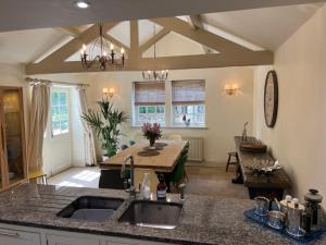 a kitchen with a sink and a table in a room at The Exclusive 6 bedroom Farm House, Markington incl heated pool and The Richmond Hill one bedroom Cottage in Ingerthorpe