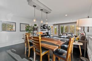 a dining room and living room with a wooden table and chairs at Chalet Harmony by Rendez-Vous Mont-Tremblant in Mont-Tremblant