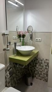 Un baño con un lavabo blanco y un espejo. en Edsan, en Madrid
