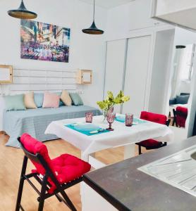 sala de estar con mesa blanca y sillas rojas en Edsan, en Madrid 6 fotos más