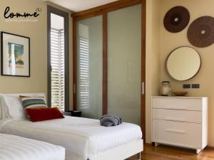 a bedroom with two beds and a mirror and a dresser at lomme Private Beach House in Cha Am +18 photos