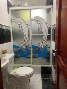 a bathroom with a shower with dolphins painted on the wall at Casa Brankonrald in San Cristóbal
