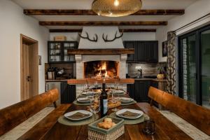 a dining room with a table and a fireplace at Villa Stella Verde - Wellness Villa with a swimming pool, hot tub and sauna in Ravna Gora