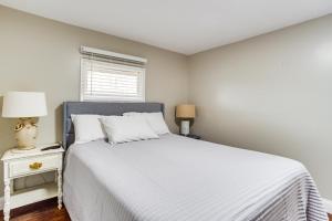 Un dormitorio con una cama blanca y una ventana. en Lakefront Getaway with Porch in Athens Area!, en Statham