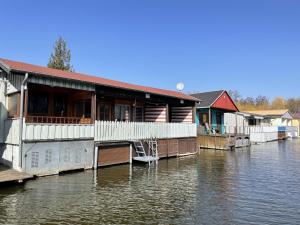 a row of houses on a dock on a river at Bootshaus in Mirow mit überdachter Terrasse in Mirow
