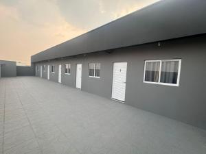 a row of buildings with white doors and windows at Pousada Parque do Lago in Sinop