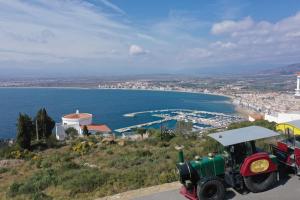 a tractor parked on top of a hill next to the water at Roses in Roses