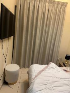 a bedroom with a bed and a gray curtain at 1BHK Furnished Apartment in Dubai