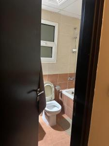 a bathroom with a toilet and a bath tub at 1BHK Furnished Apartment in Dubai