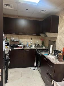 a kitchen with brown cabinets and a counter top at 1BHK Furnished Apartment in Dubai