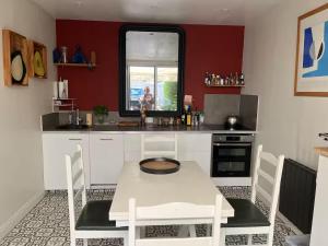 a kitchen with a white table and a window at Maison COZY d'Anne So in Wimereux