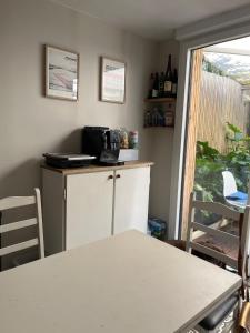 a kitchen with a counter and a table and a window at Maison COZY d'Anne So in Wimereux +4 photos