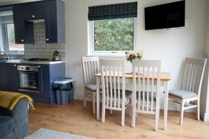 a kitchen with a table and chairs and a kitchen with a stove at The Lodge in Llangollen