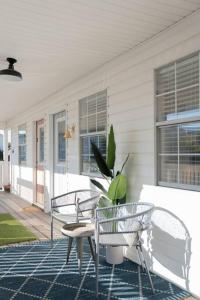 une terrasse avec 2 chaises et une table sur une maison dans l'établissement Beach Haven Tybee - Main, à Tybee Island