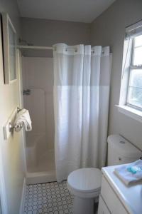 une salle de bain blanche avec douche et toilettes dans l'établissement Beach Haven Tybee - Main, à Tybee Island 54 autres photos