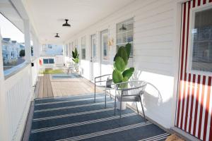une terrasse couverte avec des chaises et une table sur une maison dans l'établissement Beach Haven Tybee - Main, à Tybee Island