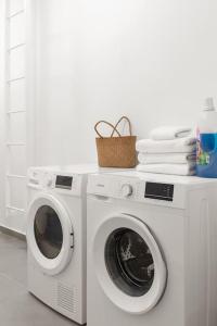 a washing machine with a basket on top of it at Luxury Garden Studio Apartment 2 in Tel Aviv