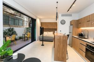 a room with a kitchen and a bedroom with a bed at Luxury Garden Studio Apartment 2 in Tel Aviv +12 photos