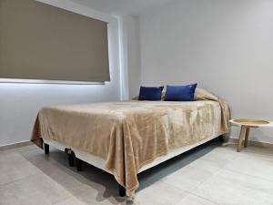 a bedroom with a bed with blue pillows on it at Departamento de Lujo sobre Costanera in Posadas +11 photos