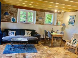 a living room with a couch and a table at Gîte Cornouaille piscine ou jacuzzi in Saint-Évarzec
