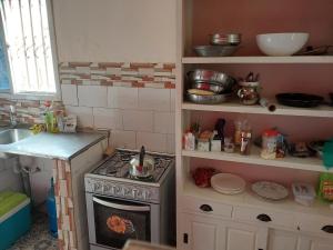 a kitchen with a stove and a counter top at Sunshine Guesthouse Bafuloto in Bafuloto +58 photos