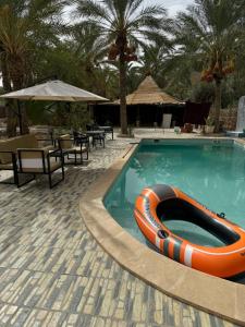 a swimming pool with an orange and white raft in it at Villa touareg in Tozeur