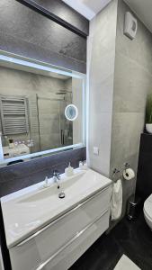 a bathroom with a white sink and a mirror at Crystal Baltic 222 in Dziwnówek +40 photos