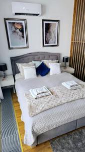 a bedroom with a large bed with two tables at Crystal Baltic 222 in Dziwnówek