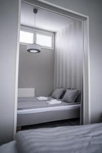 een slaapkamer met een bed met een raam en een spiegel bij Apartment Siihtala - suuri saunallinen huoneisto in Joensuu