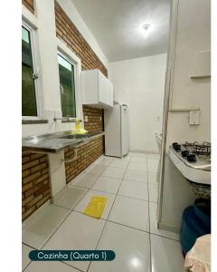 a white kitchen with a sink and a refrigerator at Condomínio Chalés Santo Antônio - Flecheiras in Trairi