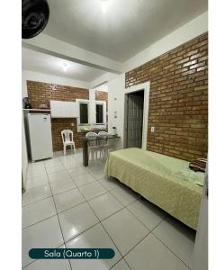 a bedroom with a bed and a kitchen with a table at Condomínio Chalés Santo Antônio - Flecheiras in Trairi