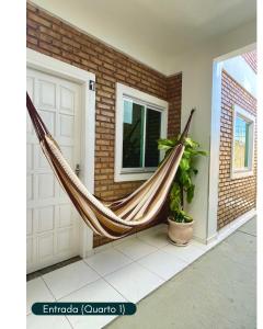 a hammock in front of a house at Condomínio Chalés Santo Antônio - Flecheiras in Trairi