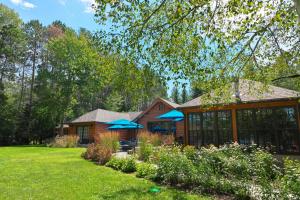 Ein Haus mit zwei blauen Regenschirmen im Garten in der Unterkunft Haliburton Post House in Minden