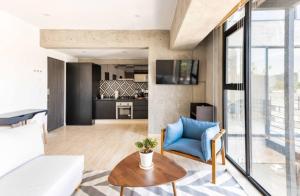 ein Wohnzimmer mit einem blauen Stuhl und einem Tisch in der Unterkunft CH604 1-1BR 1 BTH Deluxe in Mexiko-Stadt