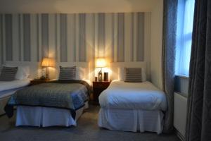 een hotelkamer met 2 bedden en een raam bij Woodfield House Hotel in Limerick