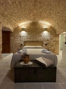 a bedroom with a bed in a stone wall at Masseria Ramasian in Monopoli