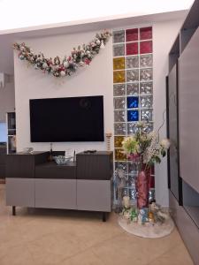 a living room with a flat screen tv on a wall at Novoli Chic: Cuore di Firenze in Florence +5 photos