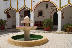 a fountain in the middle of a courtyard in a building at Lair De La Mer Resort Hotel in Sidi Kaouki