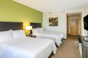 een hotelkamer met twee bedden en een flatscreen-tv bij Holiday Inn Express Managua by IHG in Managua +57 foto's